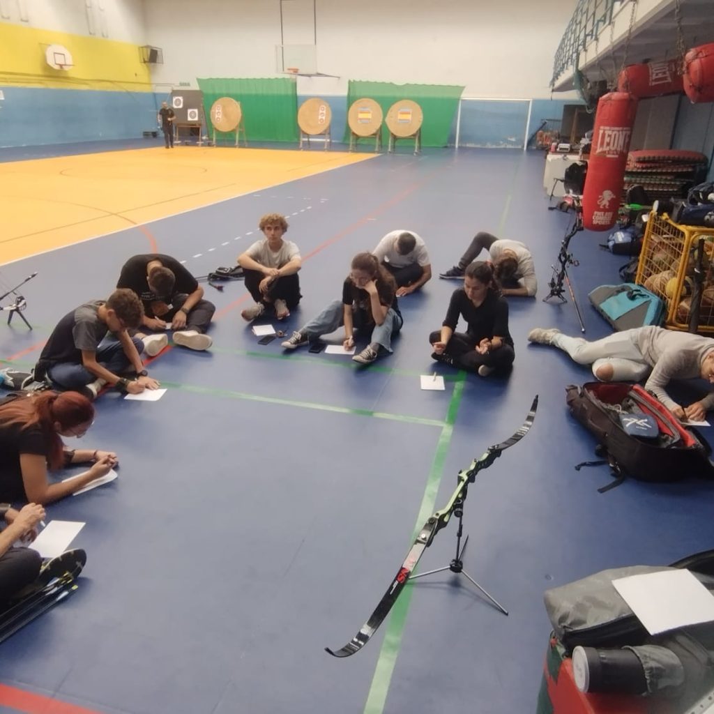 Allenamento indoor della sezione: atleti, archi e bersagli in palestra